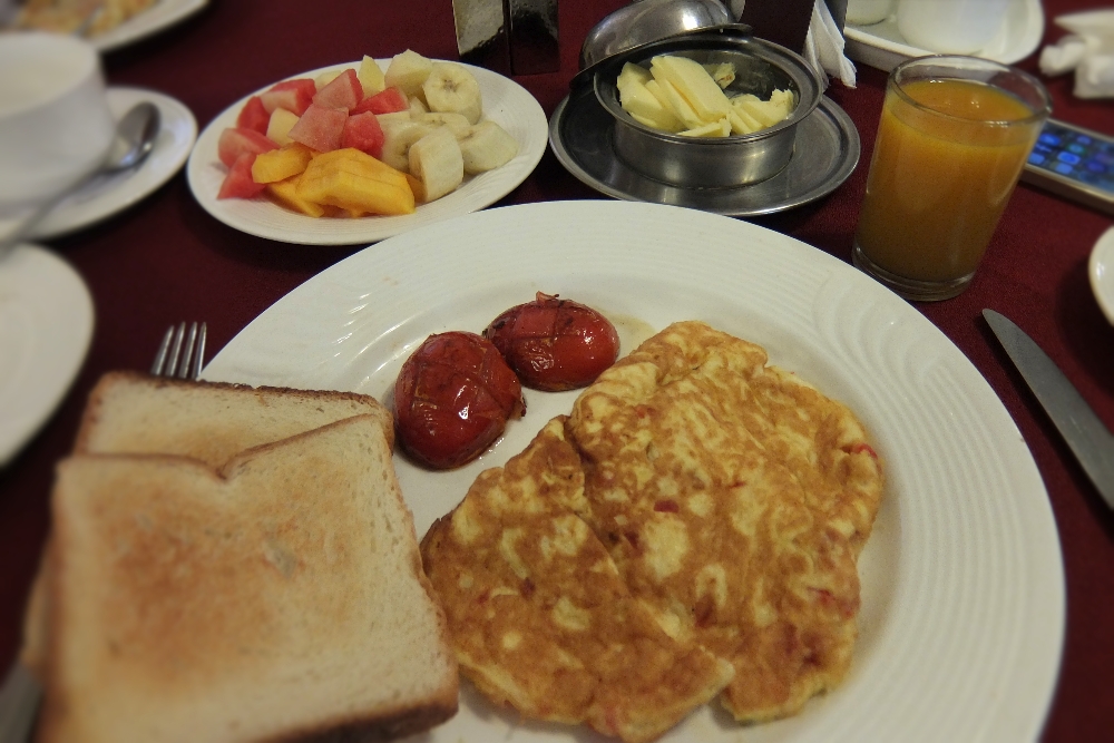 Delicious Breakfast at Amar Mahal Hotel in Orchha India which includes omelet, juice, tea and fruits